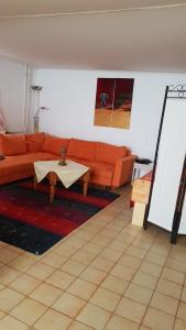 een woonkamer met een oranje bank en een tafel bij Gemütliche wohnung in Bühl