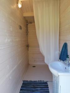 uma casa de banho com uma cortina de chuveiro e um lavatório em Jaagu majad em Suuremõisa