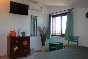1 dormitorio con 1 cama y TV en la pared en A Casa di Amici, en Tuscania