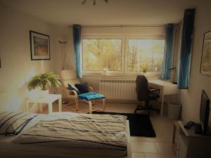 sypialnia z łóżkiem, biurkiem i oknem w obiekcie schöne Wohnung für 1-4 Gäste w mieście Ostfildern