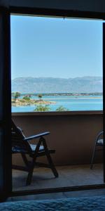 una silla sentada frente a una gran ventana en Seaview Holiday Apartments, Ventura Nin en Nin