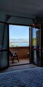 una camera da letto con finestra affacciata sull'oceano di Seaview Holiday Apartments, Ventura Nin a Nin