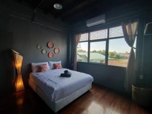 a bedroom with a bed and a large window at Tharuadaeng Old city Ayutthaya ท่าเรือแดง กรุงเก่า อยุธยา in Phra Nakhon Si Ayutthaya