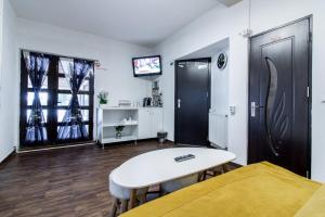 ルンカにあるTransalpina Spaのテーブル、ベッド、テレビが備わる客室です。