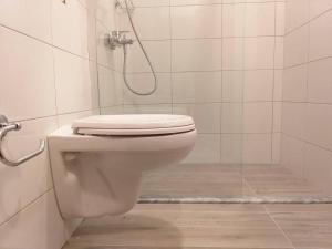 a bathroom with a toilet and a shower at Sail Ocean View Apartments in Sarandë
