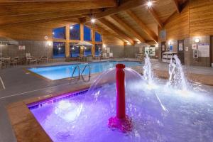 a pool with a water fountain in a building at AmericInn by Wyndham Fergus Falls Conference Center in Fergus Falls