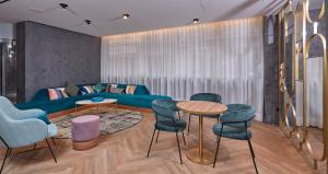 a living room with a blue couch and chairs at Occidental Alicante in Alicante