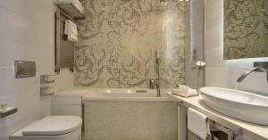 bagno bianco con lavandino e servizi igienici di Hotel Villa Blu Capri ad Anacapri