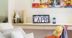 una sala de estar con un estante con reloj en Hotel Villa Blu Capri, en Anacapri