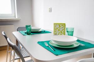 Una mesa de comedor con platos y vasos encima. en Apartament Zielony Krakowskie Przedmieście 26/2, en Lublin