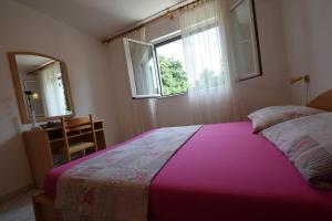 a bedroom with a bed and a mirror and a window at Apartment Sunny 1 in Njivice