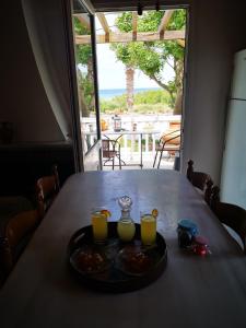 a table with a tray of food and two glasses of orange juice at By the sea in Andros