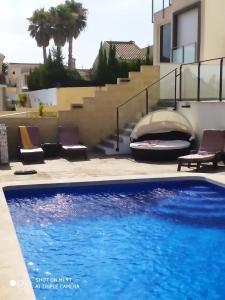 a blue swimming pool in front of a house at Villa Don Pedro in Gran Alacant