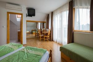 a bedroom with two beds and a dining room at Balaton Vendégház in Balatonfüred