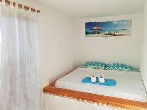 a bedroom with a bed with two towels on it at Apo Diver Beach Resort in San Juan