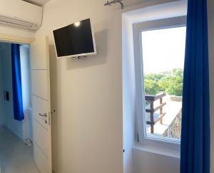 una camera con finestra e TV a parete di Appartamento Sole e Mare a Stintino