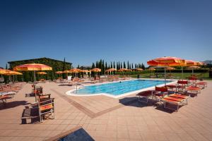 - une piscine avec des tables, des chaises et des parasols dans l'établissement Borgo Verde, à Vada