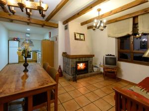 a living room with a table and a fireplace at El Casar del Puente in Boca de Huérgano