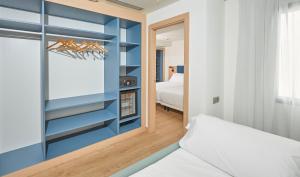 a bedroom with a bed and a blue wall at Occidental Alicante in Alicante