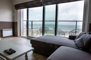 a living room with a view of the ocean at Bed & Beach Sydney in Middelkerke
