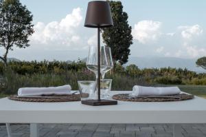 un tavolo con un bicchiere di vino e una lampada sopra di i Cacciagalli Wine Resort a Teano