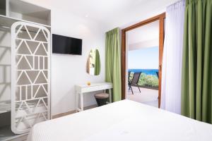 a bedroom with a bed and a view of the ocean at Villa Victoria by La Scala Beach in Limenas