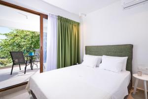 a bedroom with a bed and a large window at Villa Victoria by La Scala Beach in Limenas
