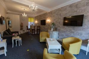 a living room with furniture and a tv on a wall at The Carlton in Blackpool