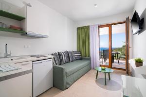 a kitchen and living room with a couch and a table at Villa Victoria by La Scala Beach in Limenas