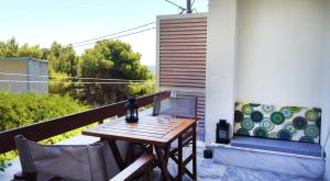 einen Holztisch und Stühle auf dem Balkon in der Unterkunft Fistiki Rooms in Agia Marina