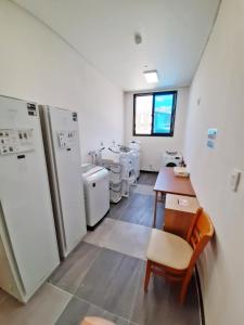 a room with a kitchen with a table and a refrigerator at Hotel Haemaru in Gwangyang