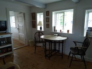 a living room with a table and chairs and windows at Baekgaarden B&B in Sandholts-Lyndelse