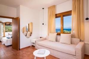 a living room with a couch and a table at Villa Victoria by La Scala Beach in Limenas