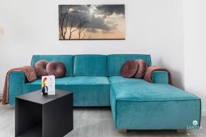 niebieską kanapę w salonie ze stołem w obiekcie Jantar Apartamenty - Nadmorskie Tarasy SPA 2 w Kołobrzegu