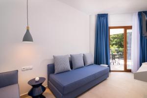 a living room with a blue couch and a patio at Villa Victoria by La Scala Beach in Limenas