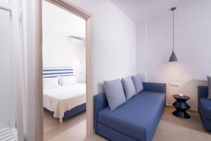 a bedroom with a mirror and a blue couch at Villa Victoria by La Scala Beach in Limenas