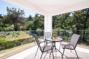a dining room with a table and chairs on a balcony at Villa Victoria by La Scala Beach in Limenas