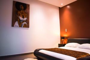 una camera con un letto e un dipinto sul muro di Le First Concept a Dakar
