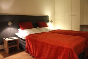 - une chambre avec un grand lit et une couverture rouge dans l'établissement Ylläs Majoitus Chalets 8, 8101, à Ylläsjärvi