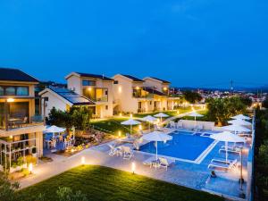an aerial view of a villa with a pool at night at Miroes Suites in Nikiti