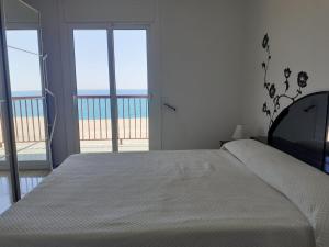 1 dormitorio con 1 cama y vistas a la playa en Suitur apartamento primera linea mar vistas playa, en Canet de Mar