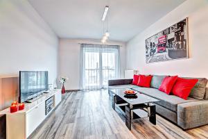 a living room with a couch and a tv at Apartamenty Homely Place - Parking in Poznań