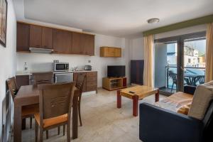 a kitchen and living room with a table and a couch at Hotel LIVVO Corralejo Beach in Corralejo
