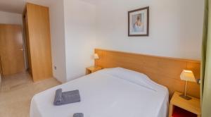 a bedroom with a white bed with a wooden headboard at Hotel LIVVO Corralejo Beach in Corralejo
