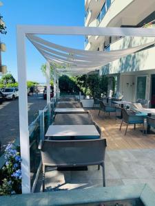 - une rangée de tables et de chaises sur la terrasse dans l'établissement Hotel Majestic, à Gabicce Mare