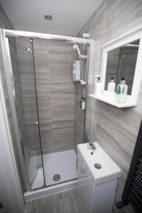 a bathroom with a shower and a toilet and a sink at Lynwood House in Southport