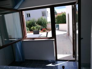 an open door with a view of a courtyard at Ferienhaus Bozena Appartment 1 in Vrsar