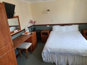 a hotel room with a bed and a desk with a computer at The Lugger Inn in Weymouth