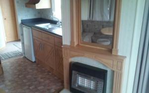 a kitchen with a fireplace with a sink and a counter at Hemsby Long Beach in Great Yarmouth