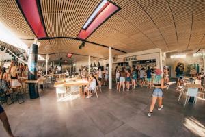 a group of people walking around a shopping mall at FarOut - BeachResort & Camping in Mylopotas